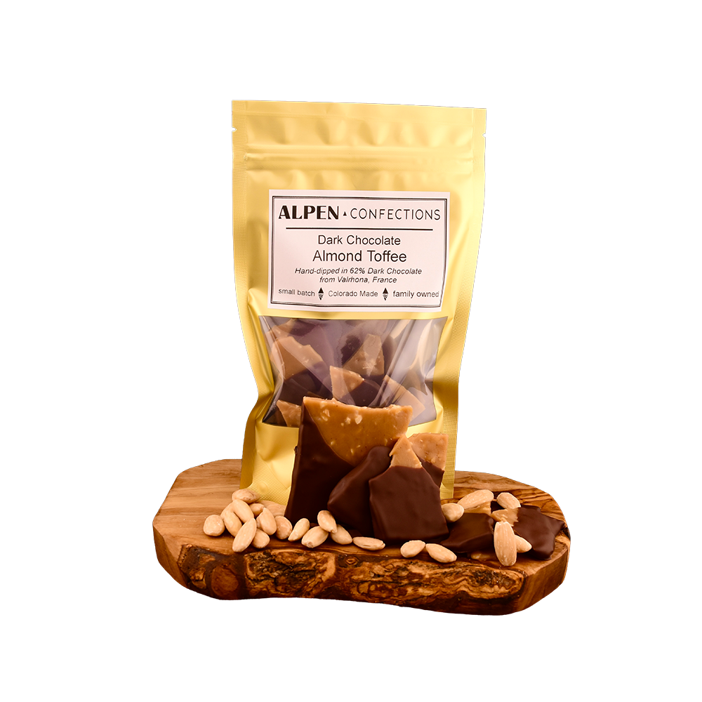 Almond toffee pouch, loose chocolate-dipped pieces and almonds on a wooden serving board