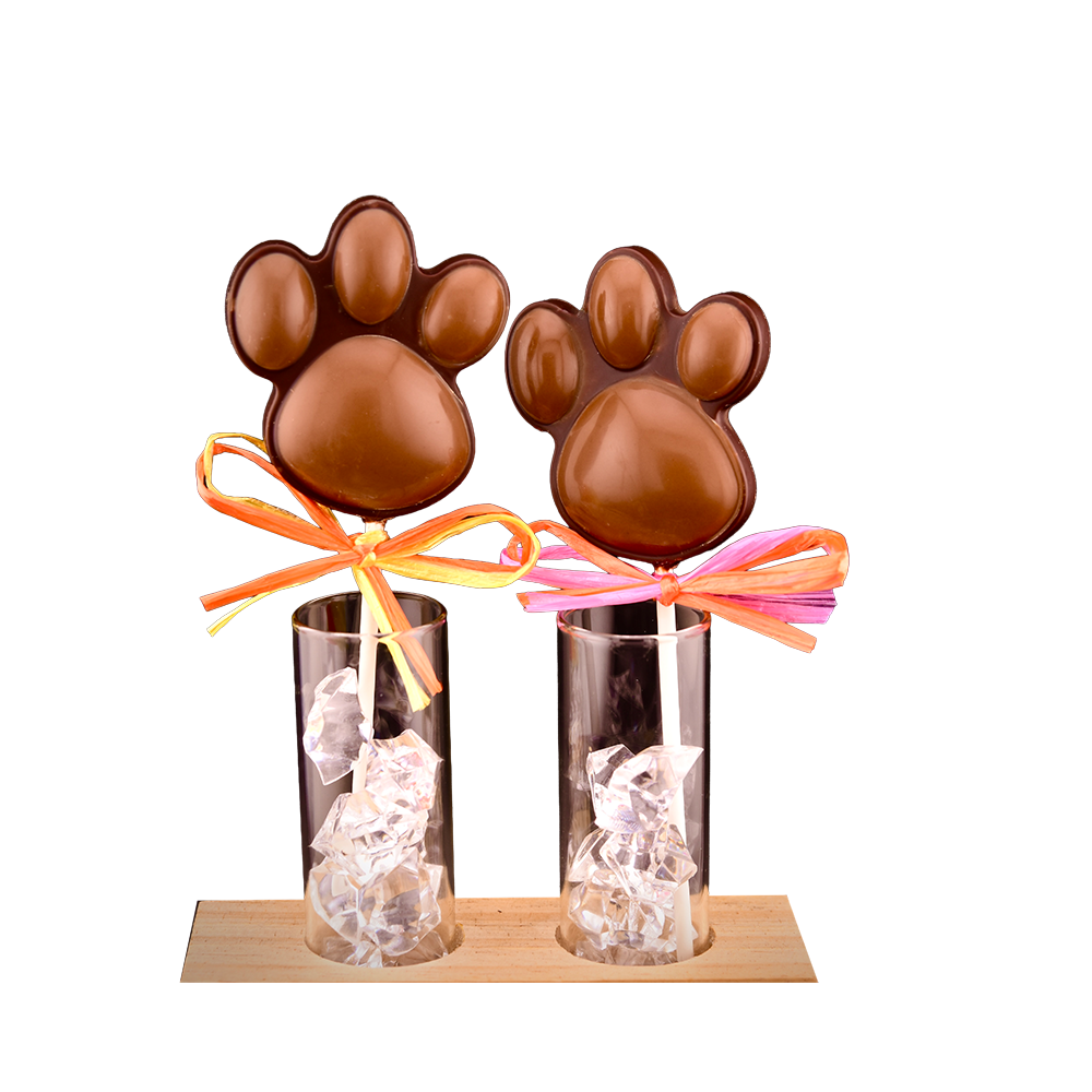 Two bear paw lollipops with colorful ribbons in glass display stands with decorative filler and a wooden base