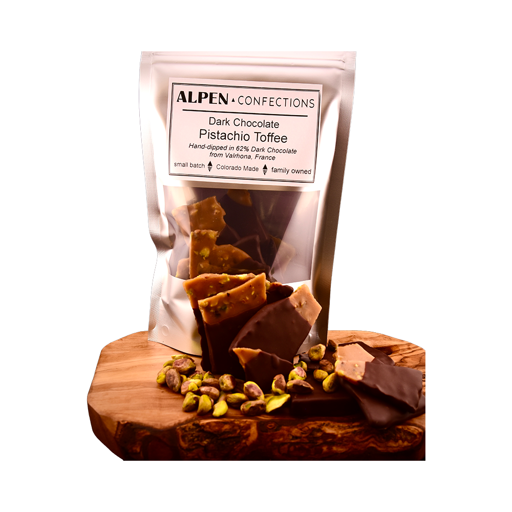 Pistachio toffee pouch, loose chocolate-dipped pieces and pistachios on a wooden serving board