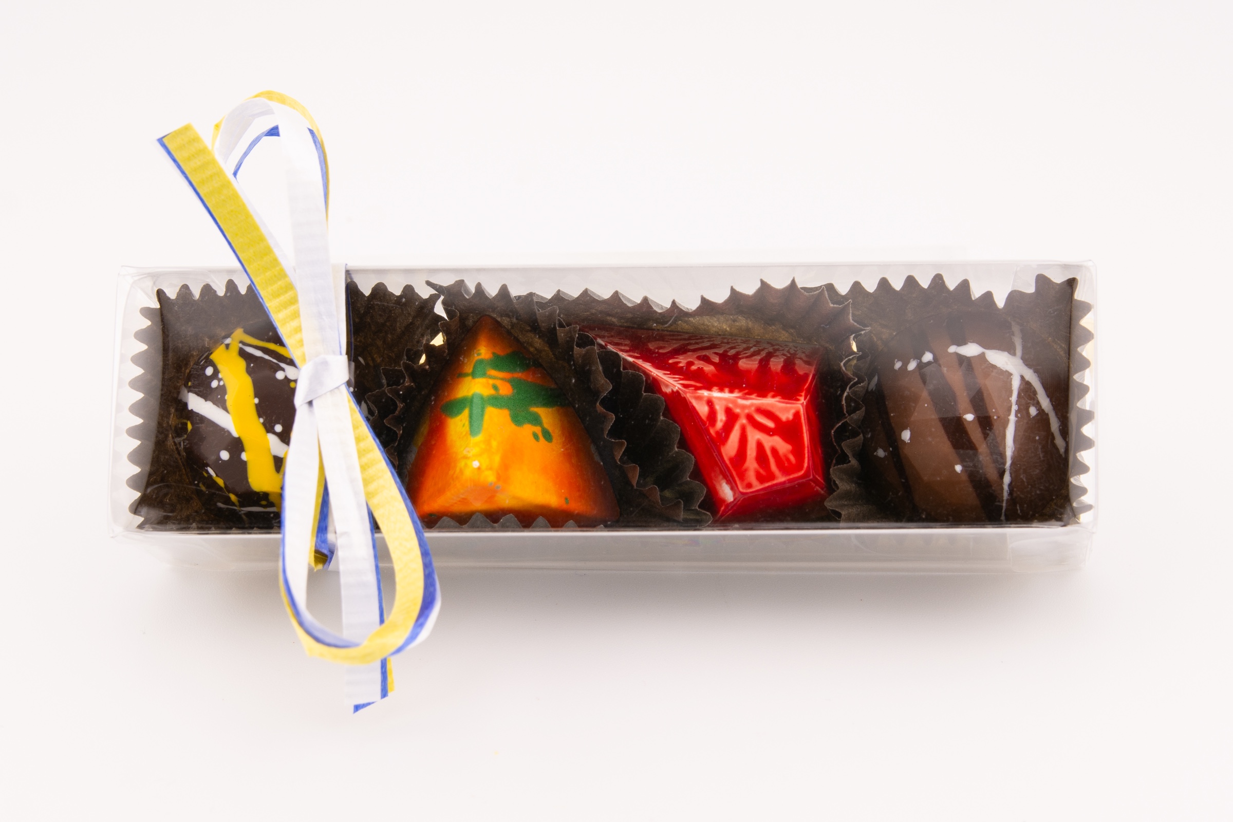 Four Alpen confections in a clear box with a raffia bow