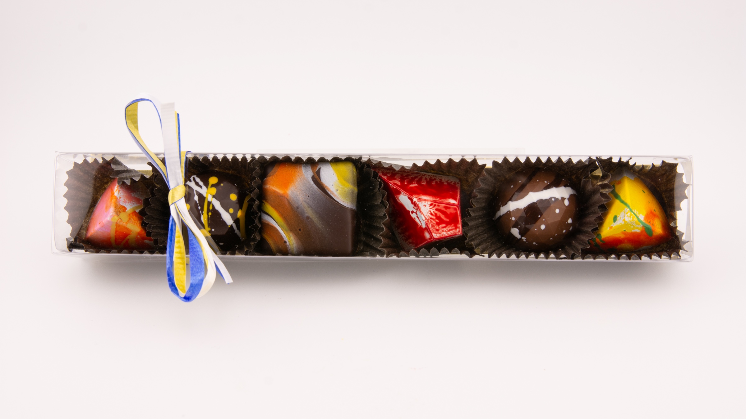 Six Alpen confections in a clear box with a raffia bow