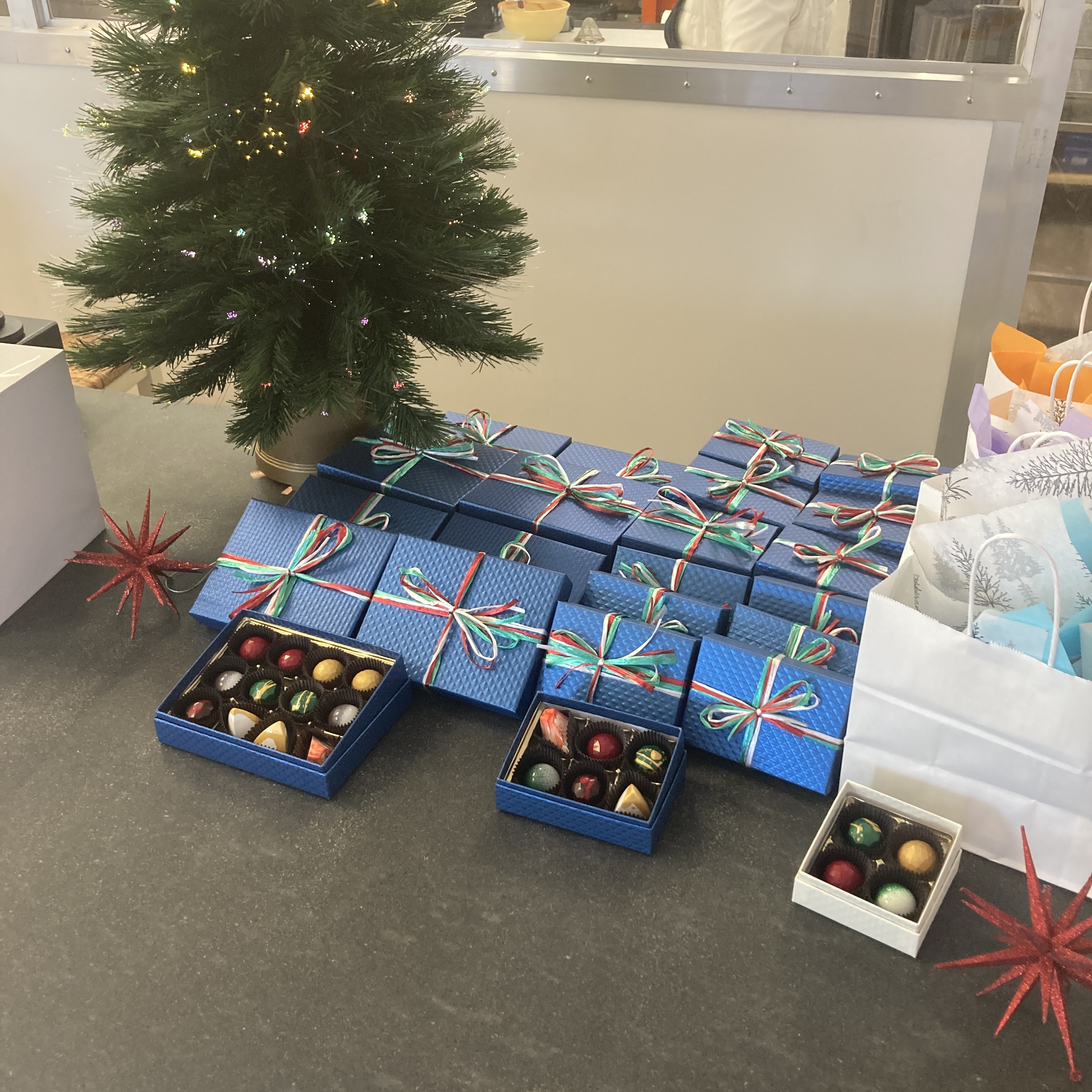 Actual blue quilted Alpen gift boxes with raffia bows and open assortments